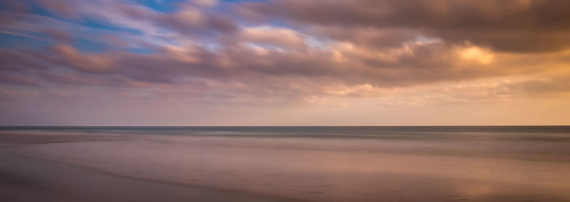 Scenic view of beach against sky during sunset