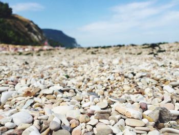 Close-up of pebbles on beach against sky