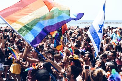 Crowd with multi colored flag at gay parade