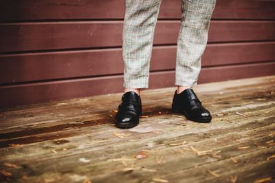 Low section of well-dressed man standing in park