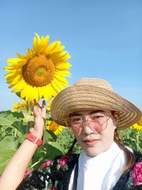 Portrait of smiling woman with yellow flower