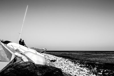 Man on beach against clear sky