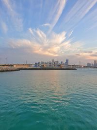 Scenic view of sea by buildings against sky