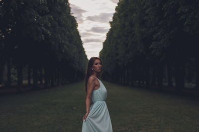 Young woman standing amidst trees