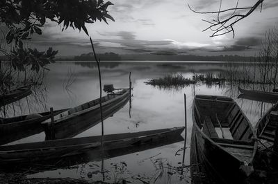 Boat moored in lake against sky