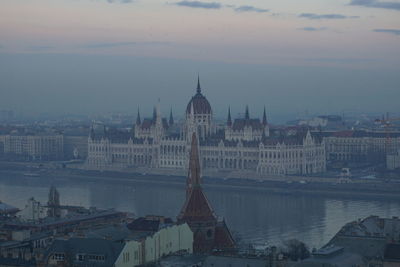 Buildings in city against sky during sunset