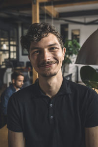 Portrait of smiling computer programmer at workplace