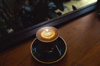 A cup of coffee latte top view with microfoam milk leaf shape foam.