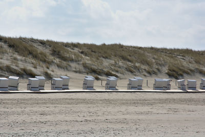 Beach huts on field against sky