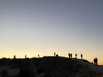 Silhouette people against clear sky during sunset