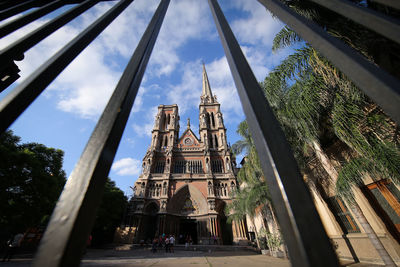 Low angle view of historic church seen through fence