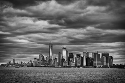 Sea by cityscape against sky