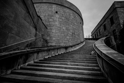 Low angle view of steps amidst buildings against sky
