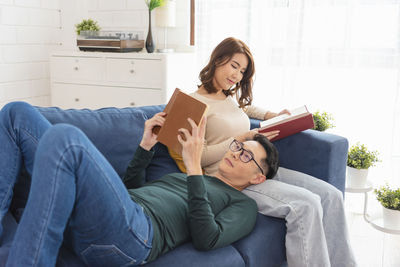 Young woman sitting on sofa at home