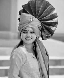 Smiling young woman wearing turban looking away while standing outdoors
