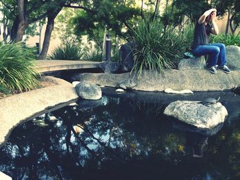 Woman standing on tree trunk