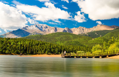 Scenic view of lake by mountains against sky