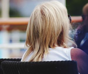 Rear view of woman sitting outdoors