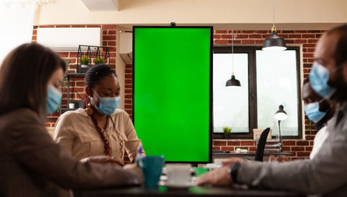 Business people wearing mask brainstorming in office