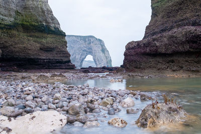 Rocks on sea shore against sky