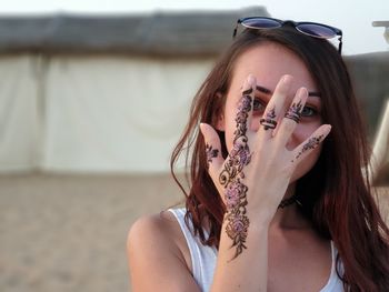 Portrait of young woman showing henna tattoo at beach