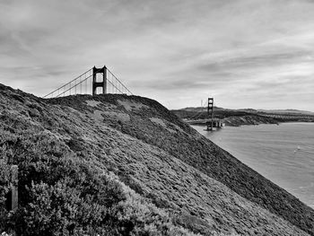 View of suspension bridge against cloudy sky