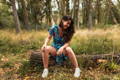 Full length of young woman sitting on field