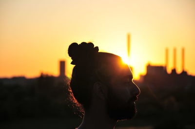 Close-up portrait of silhouette man against orange sky