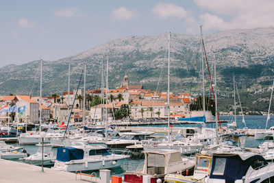 Sailboats moored at harbor