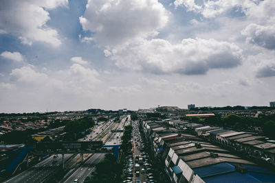 Aerial view of cityscape against cloudy sky