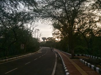 Road amidst trees against sky