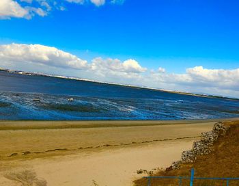 Scenic view of beach against blue sky