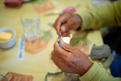 Close-up of man holding ice cream on table