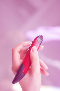 Close-up of woman hand holding pink flower