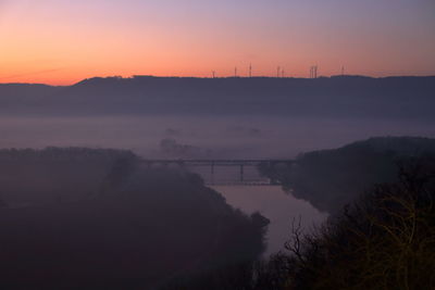 Top-down-view over valley of river weser with fog in dark shadows after sunset