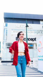 Portrait of smiling woman standing against wall