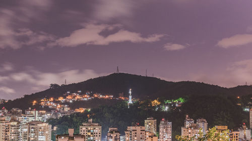 Aerial view of illuminated buildings in town against sky