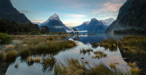 Scenic view of lake by mountains against blue sky