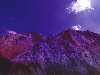 Low angle view of rocks against blue sky