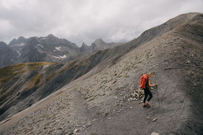 Man walking on mountain against sky