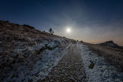 Scenic view of snow covered landscape against sky at night