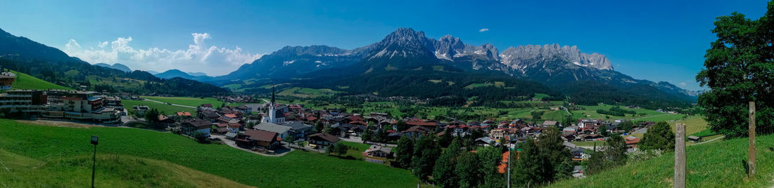 Panoramic view of trees and houses against sky