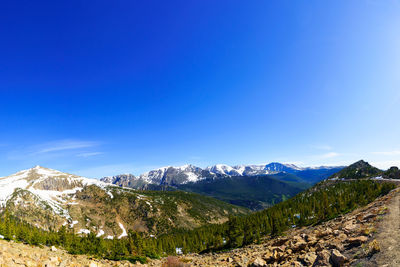 Scenic view of snowcapped mountains against blue sky