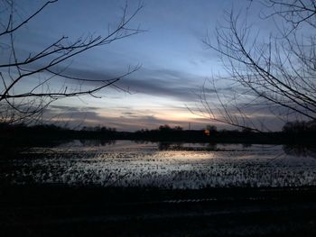 Scenic view of lake against sky at sunset