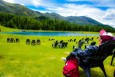 Rear view of woman with horse on field against sky