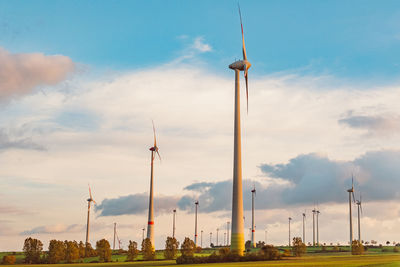 Low angle view of windmills against sky