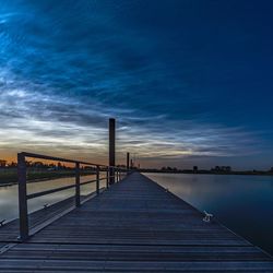 Pier over sea against sky during sunset