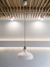 Close-up of illuminated pendant lights hanging from ceiling at home