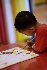 Side view of boy making drawing on table