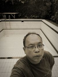 Portrait of man wearing sunglasses against railing